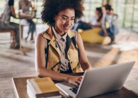 A woman on a laptop smiling