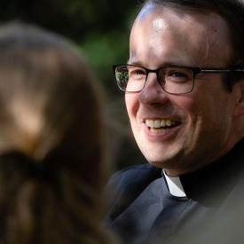 Catholic priest talking with person 