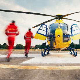 Emergency medics running toward a helicopter