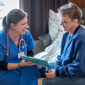 Caregiver and patient reviewing a medical chart