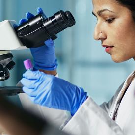 Person at a microscope working in a lab