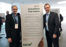 Charles Braymen and Dustin Ormond standing with an "Innovations that Inspire" banner