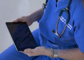 female nurse at Creighton University holding an ipad