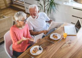 Two people sitting at a table looking at a notebook