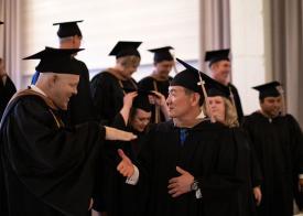 EMBA grads shaking hands